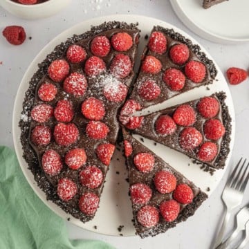 A whole Chocolate Raspberry Tart cut into slices, ready to serve.