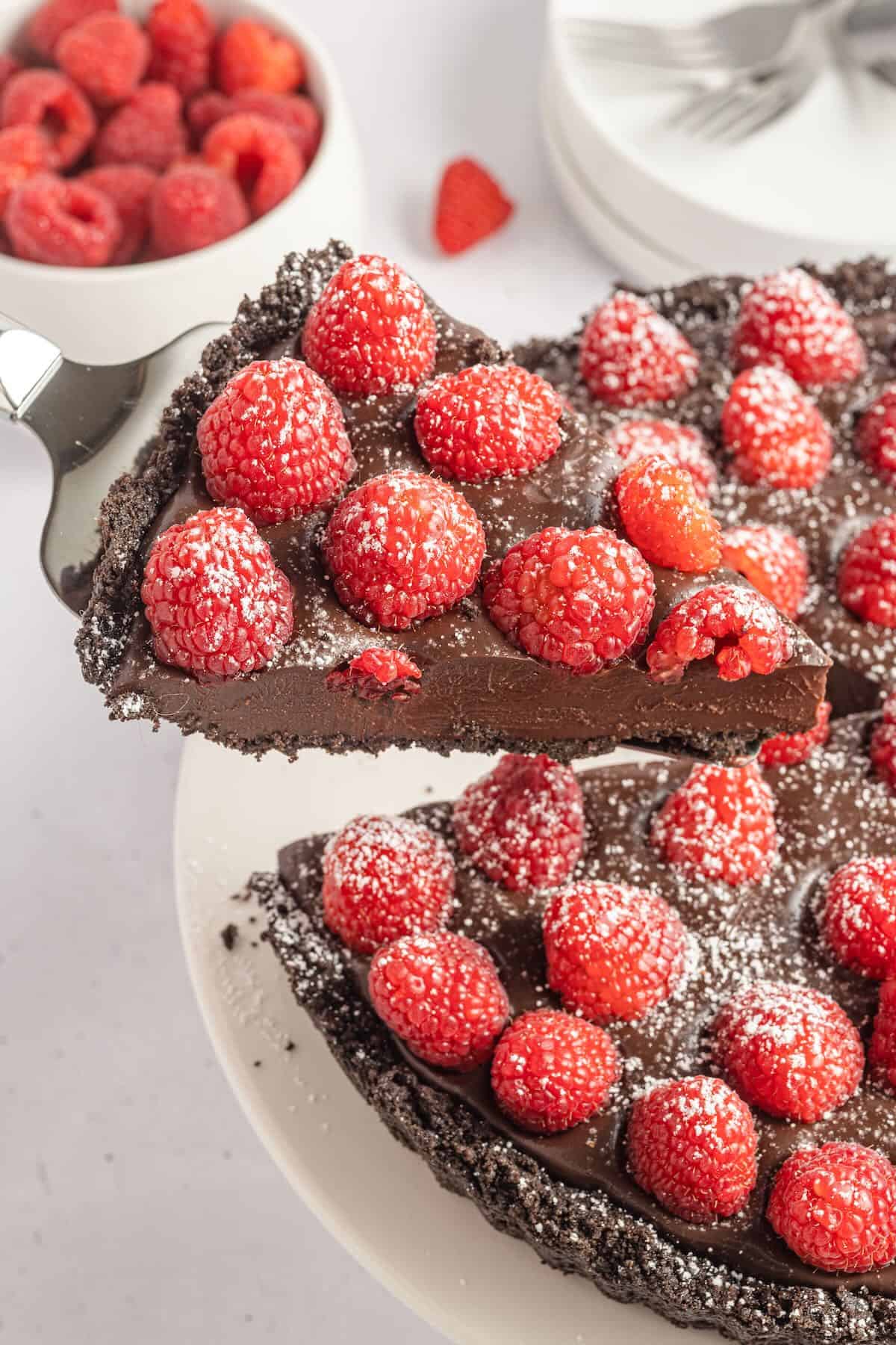 A slice of chocolate raspberry tart topped with powdered sugar.