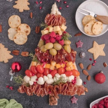 Christmas Tree Charcuterie Board is covered with meats, cheeses, and nuts.