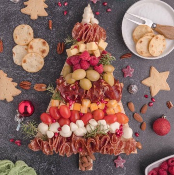Christmas Tree Charcuterie Board is covered with meats, cheeses, and nuts.