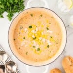 Corn and Crab Bisque in a white Dutch oven garnished with parsley.