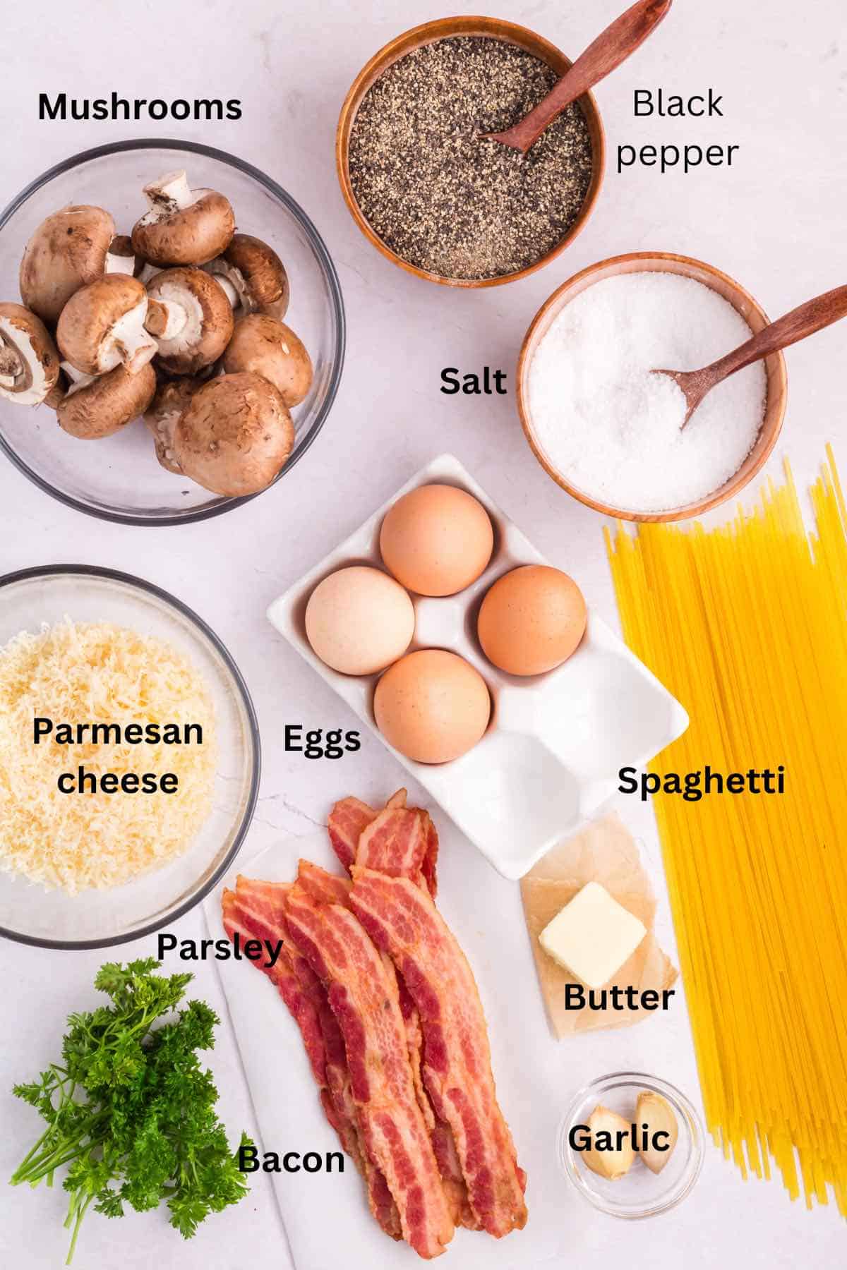 Mushroom carbonara ingredients on a counter include Parmesan cheese, eggs, and spaghetti. 