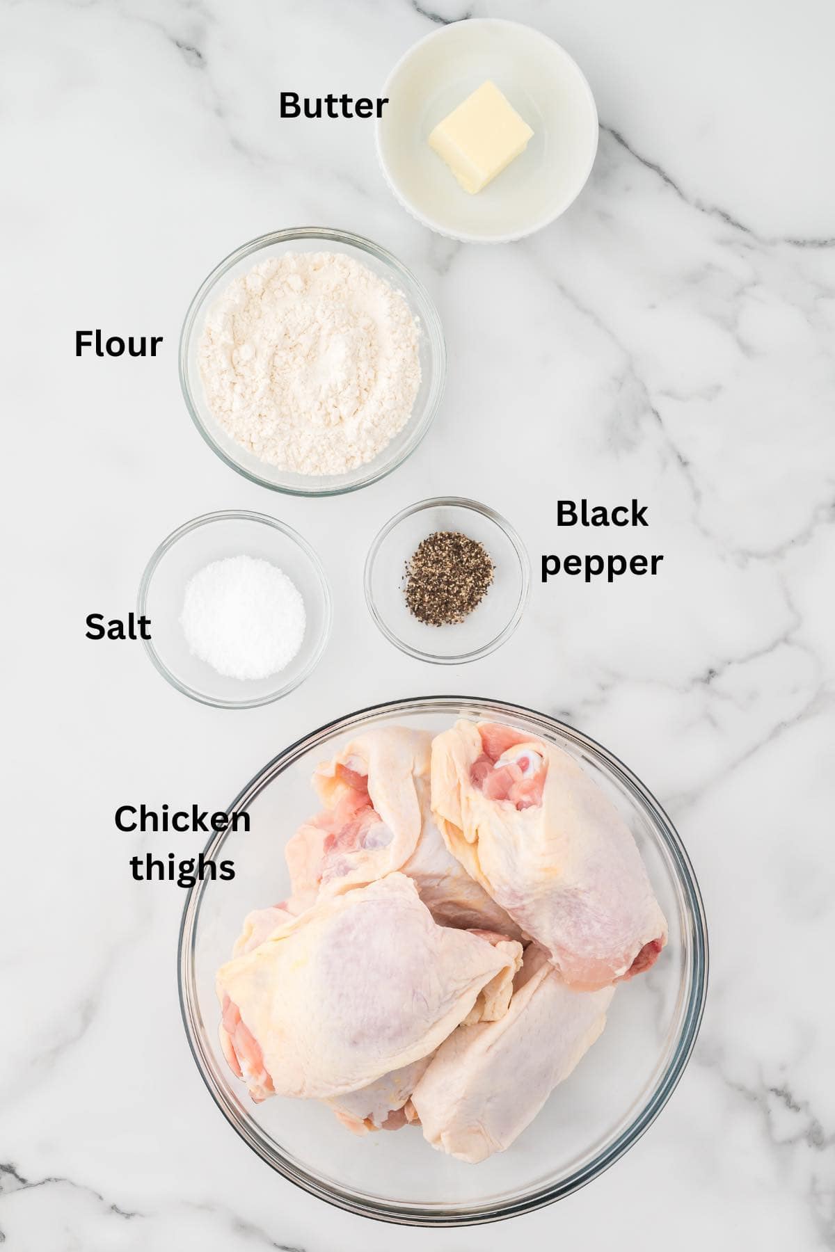 Ingredients to make fried chicken in the oven include chicken thighs, flour, and butter. 