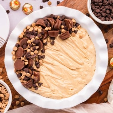 Reese's Peanut Butter Cup Pie on a white pie plate topped with peanut butter cups and chocolate chips.