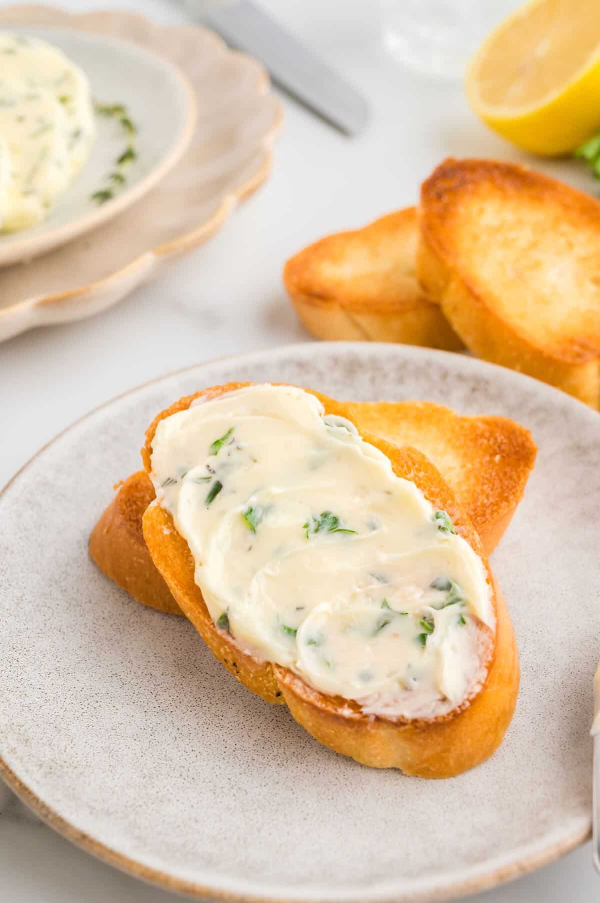 Garlic herb butter on a toasted baguette slice. 