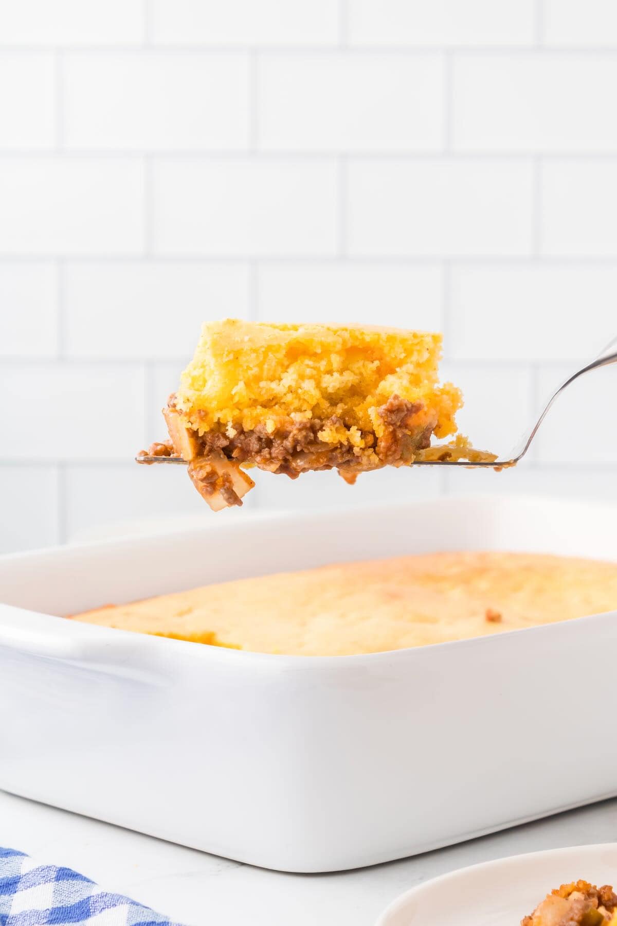 A slice on a spatula of Sloppy Joe Cornbread Casserole. 