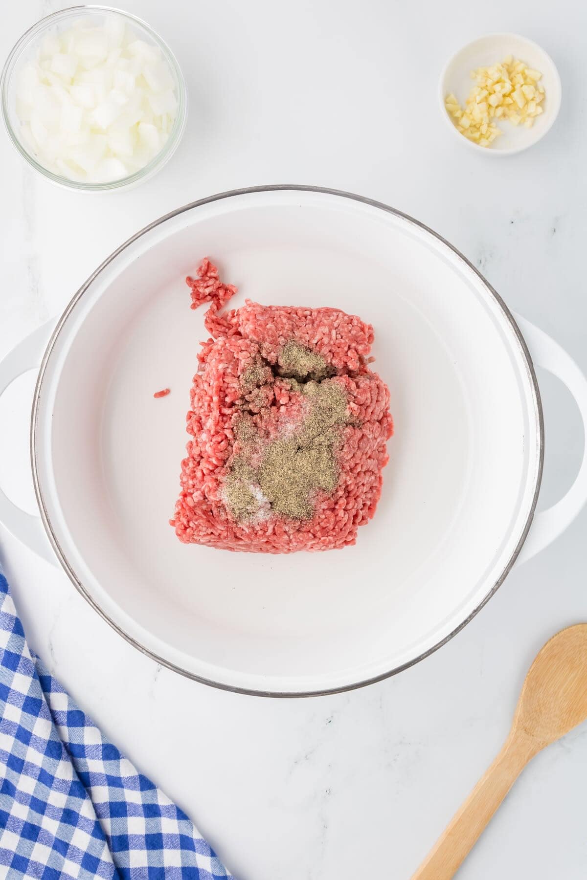 Raw ground beef in a white skillet