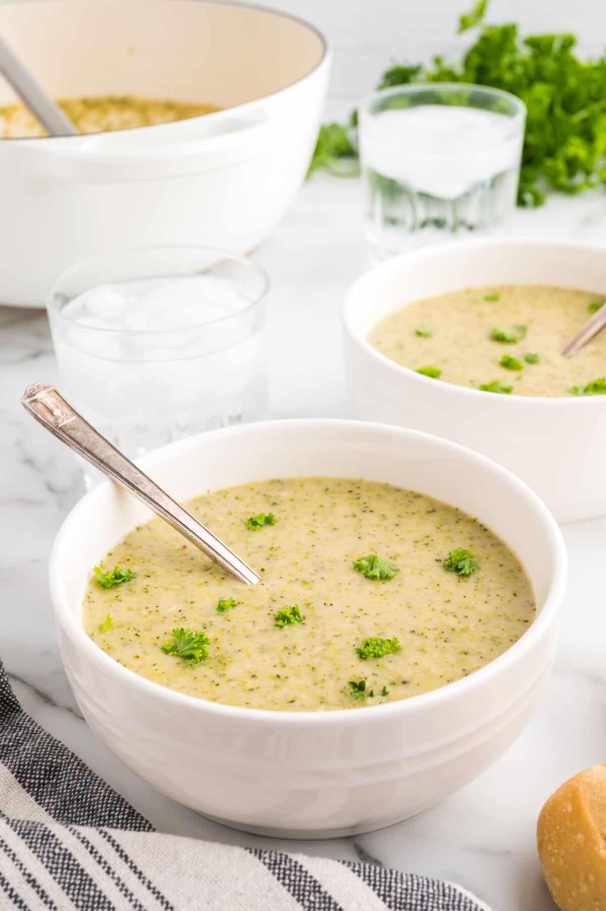 Two bowls of white bean soup with spoons in them. 