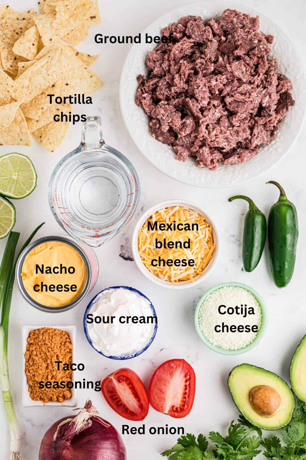 Ingredients for beef nachos including ground beef, cheese and tortilla chips. 