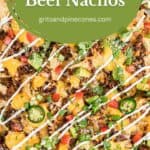 Pinterest pin showing a sheet pan full of beef nachos with sour cream drizzled over the top.