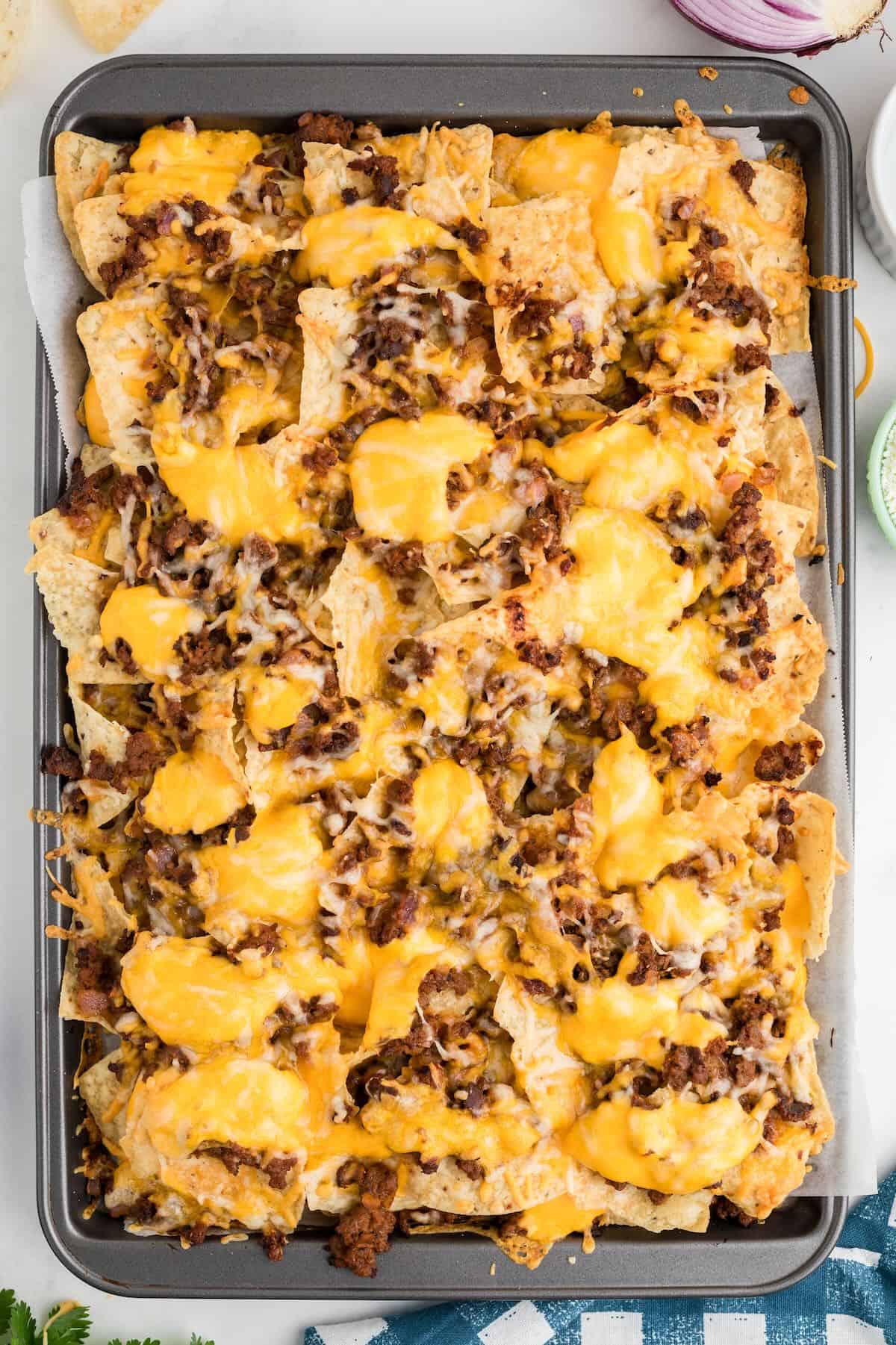 Baked beef nachos topped with melted cheese. 