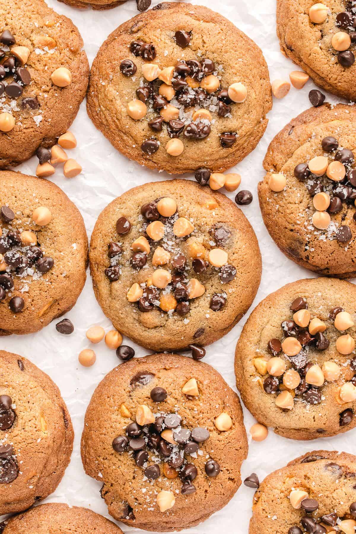 Butterscotch and chocolate chip cookies cooling on a piece of parchment paper. 