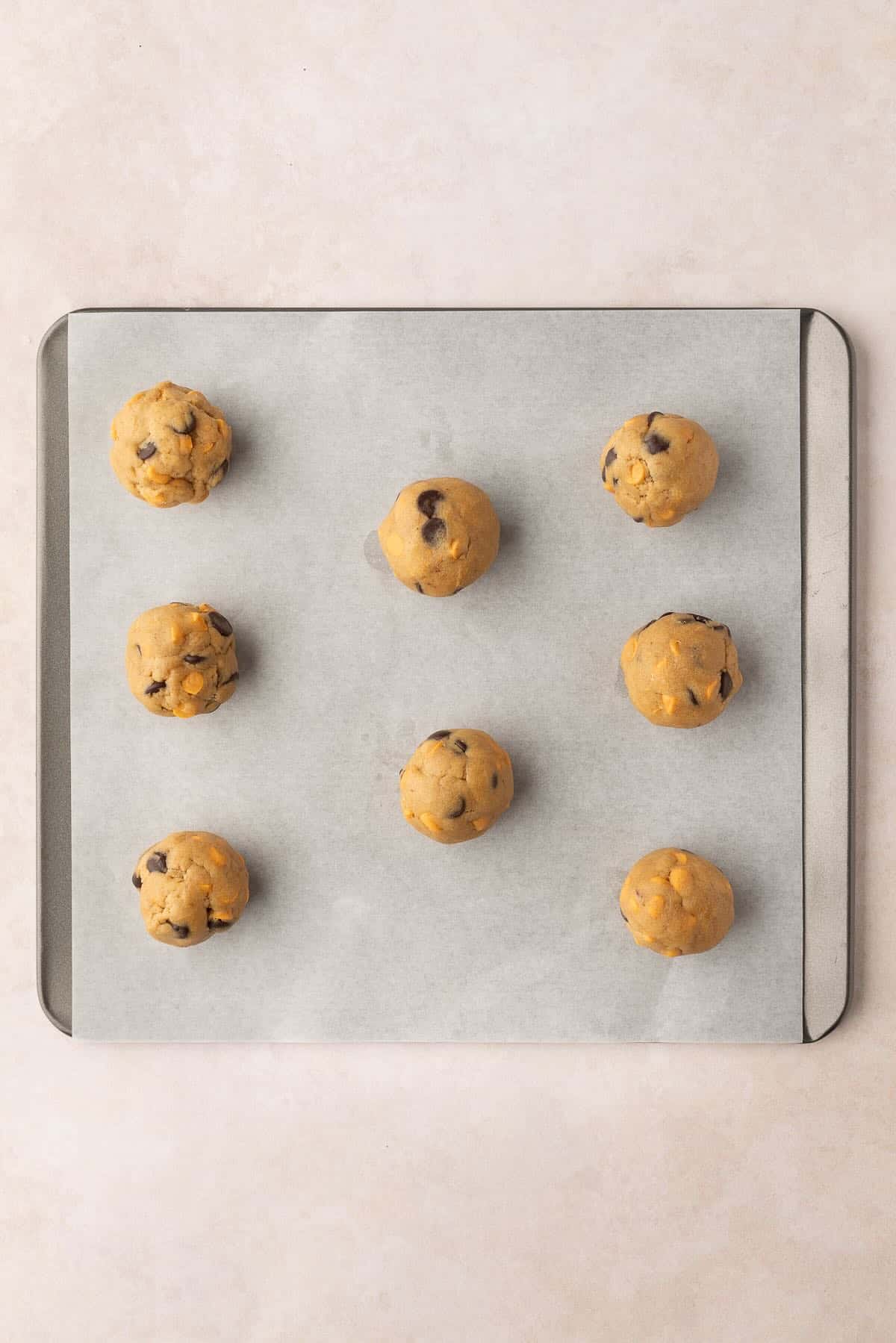 Butterscotch Chocolate Chip Cookie dough balls on a baking sheet. 