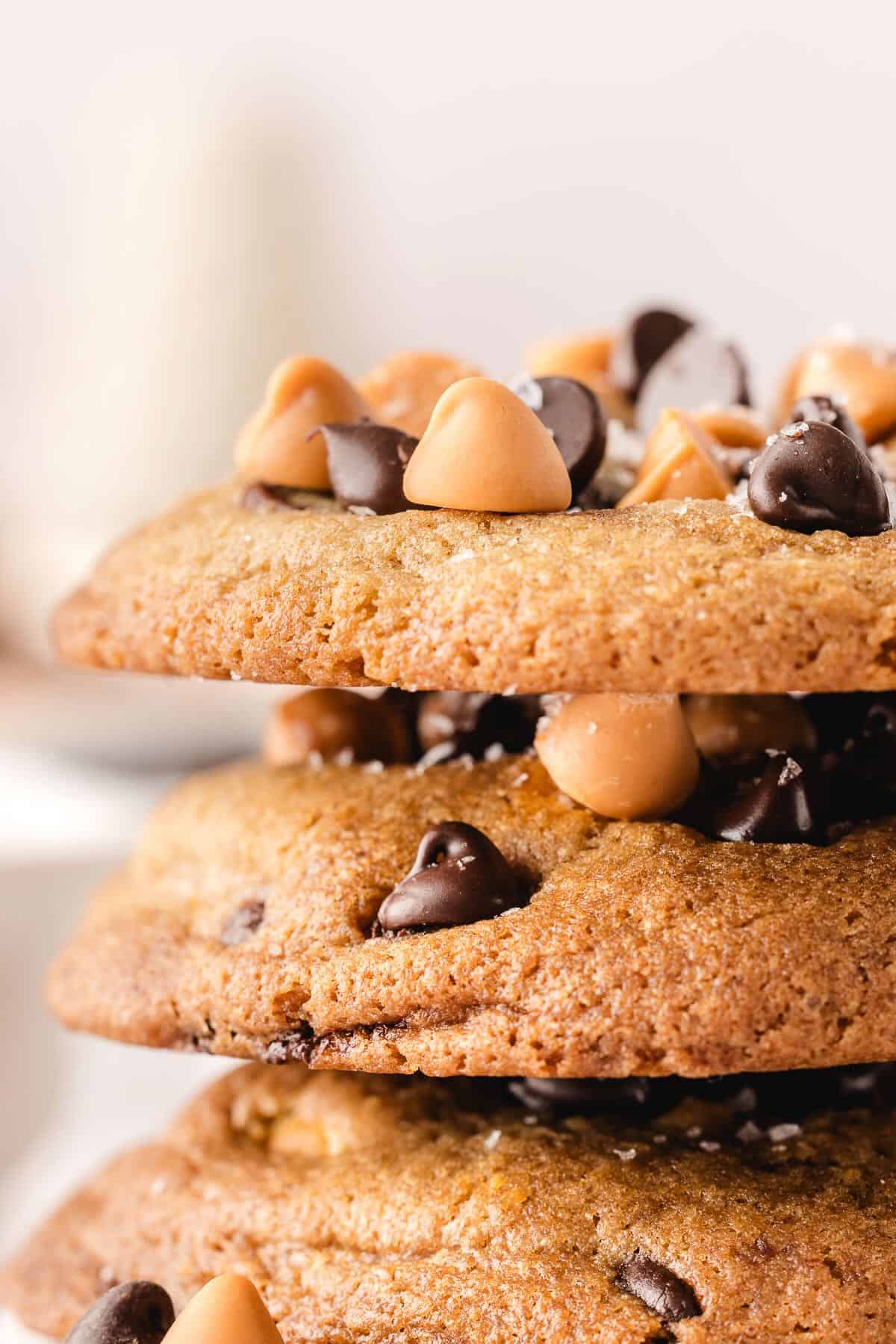 Three Butterscotch Chocolate Chip Cookies topped with sea salt and stacked.