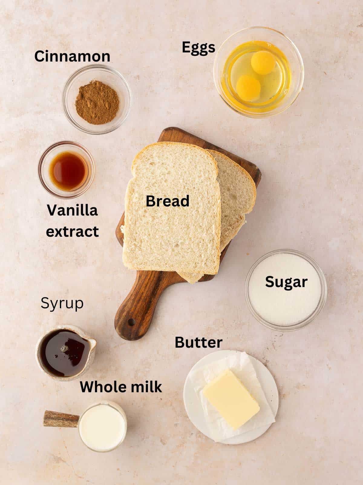 Ingredients on a counter include slices of bread, and bowls of syrup, eggs, sugar, and milk. 