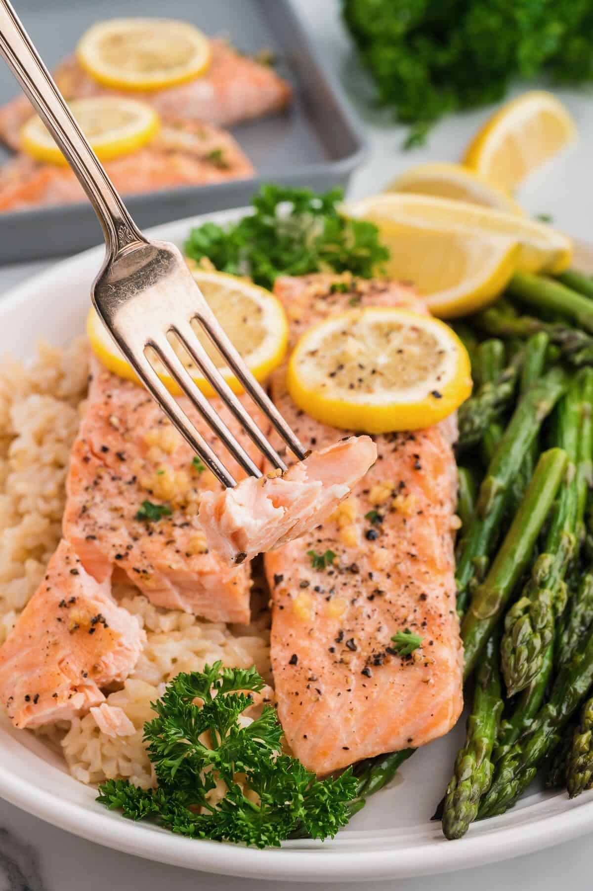 A forkful of baked lemon pepper salmon. 