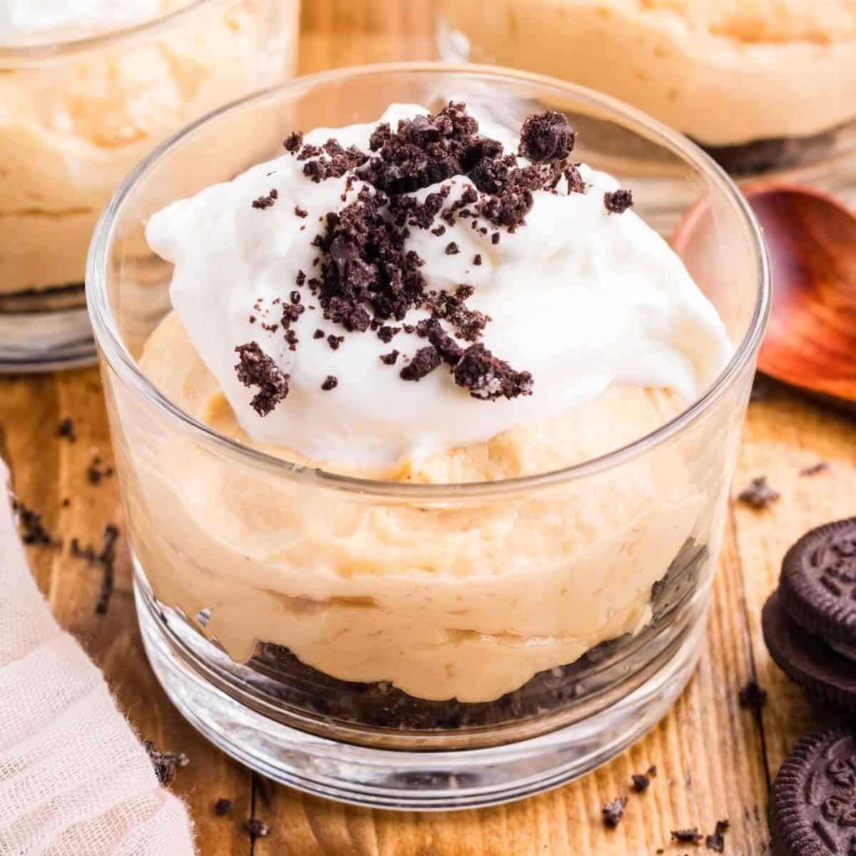 Peanut Butter Mousse topped with whipped cream and a sprinkle of crushed Oreos.