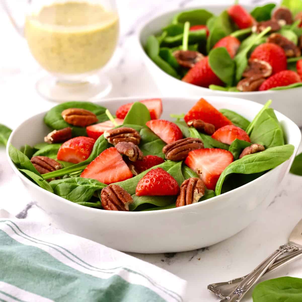 Spinach Strawberry Salad with Pecans and Poppy Seed Dressing on a table.
