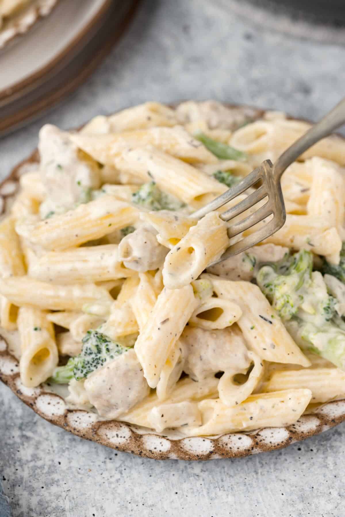 Chicken and Broccoli Pasta on a plate with a fork. 