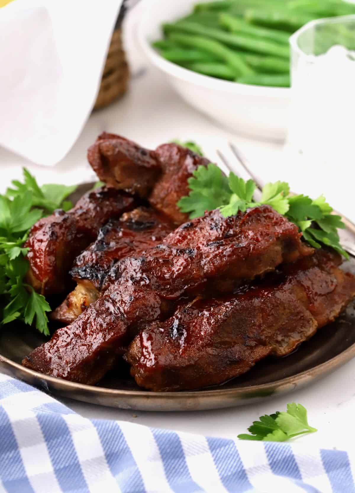 Boneless Country Style Pork Ribs on a bronze plate garnished with parsley.