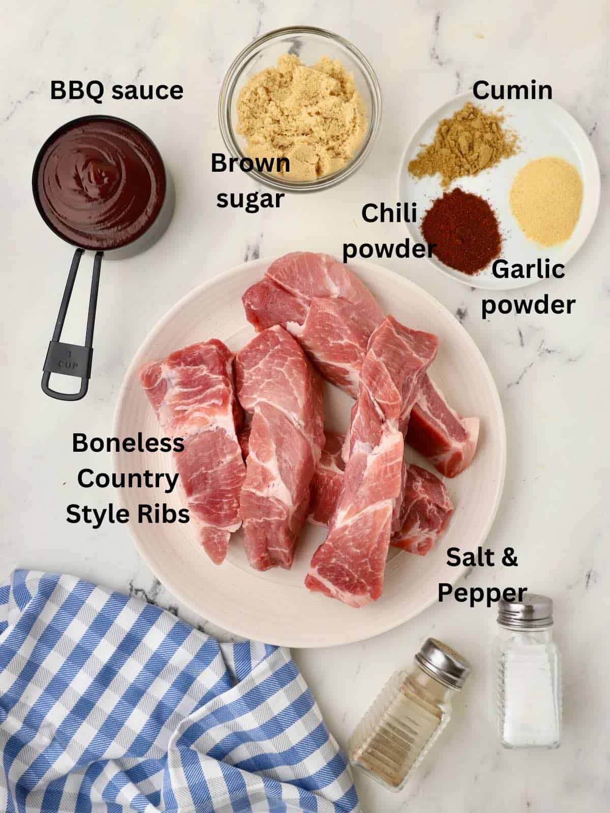 Ingredients to make oven baked ribs including boneless ribs, BBQ sauce, and ingredients for a dry rub. 