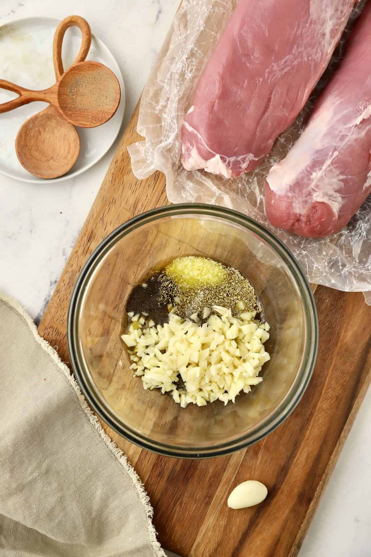 Chopped garlic, and dried rosemary, thyme and sage in a small bowl with olive oil 