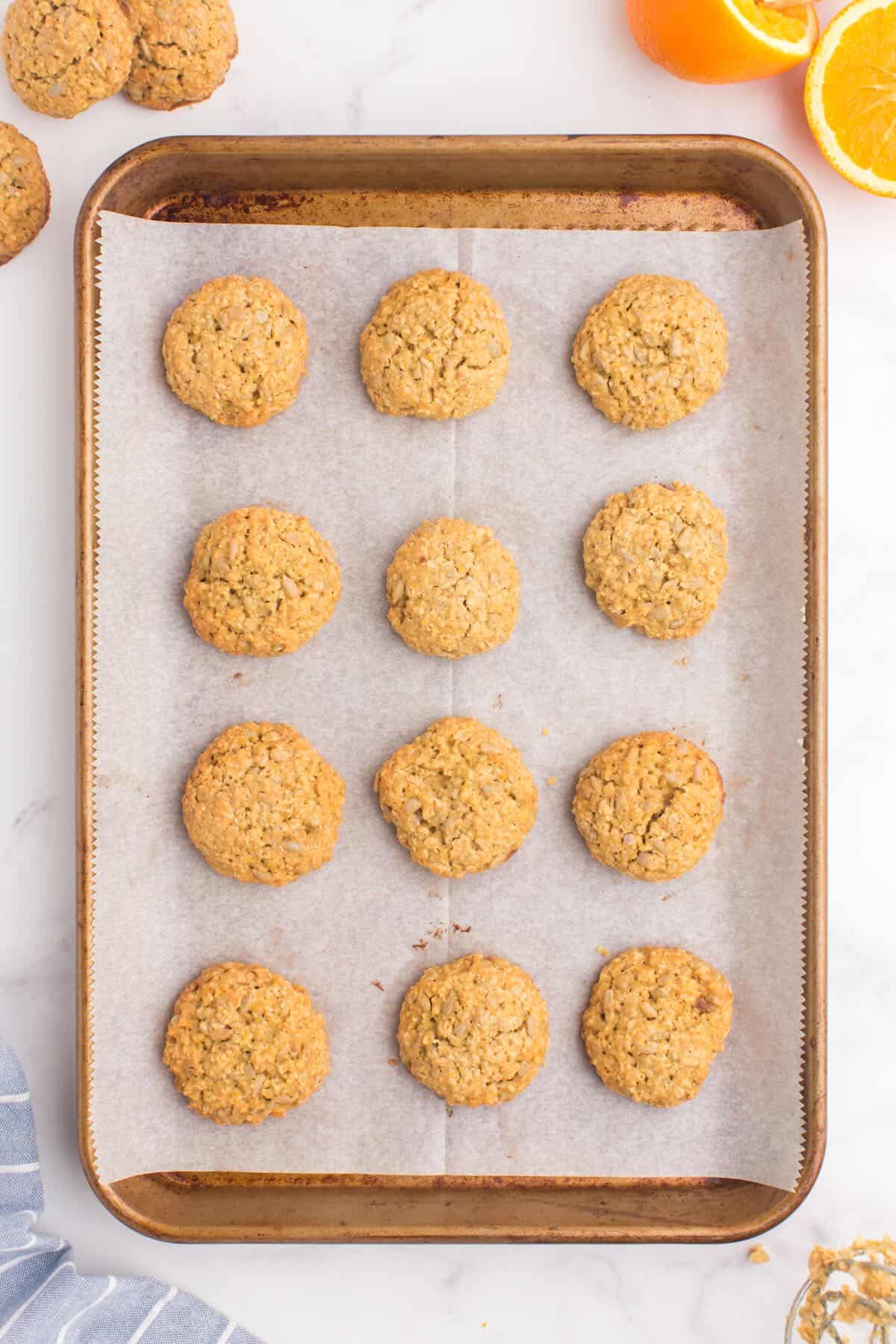 A cookie sheet lined with parchment paper and baked sunflower seed cookies. 