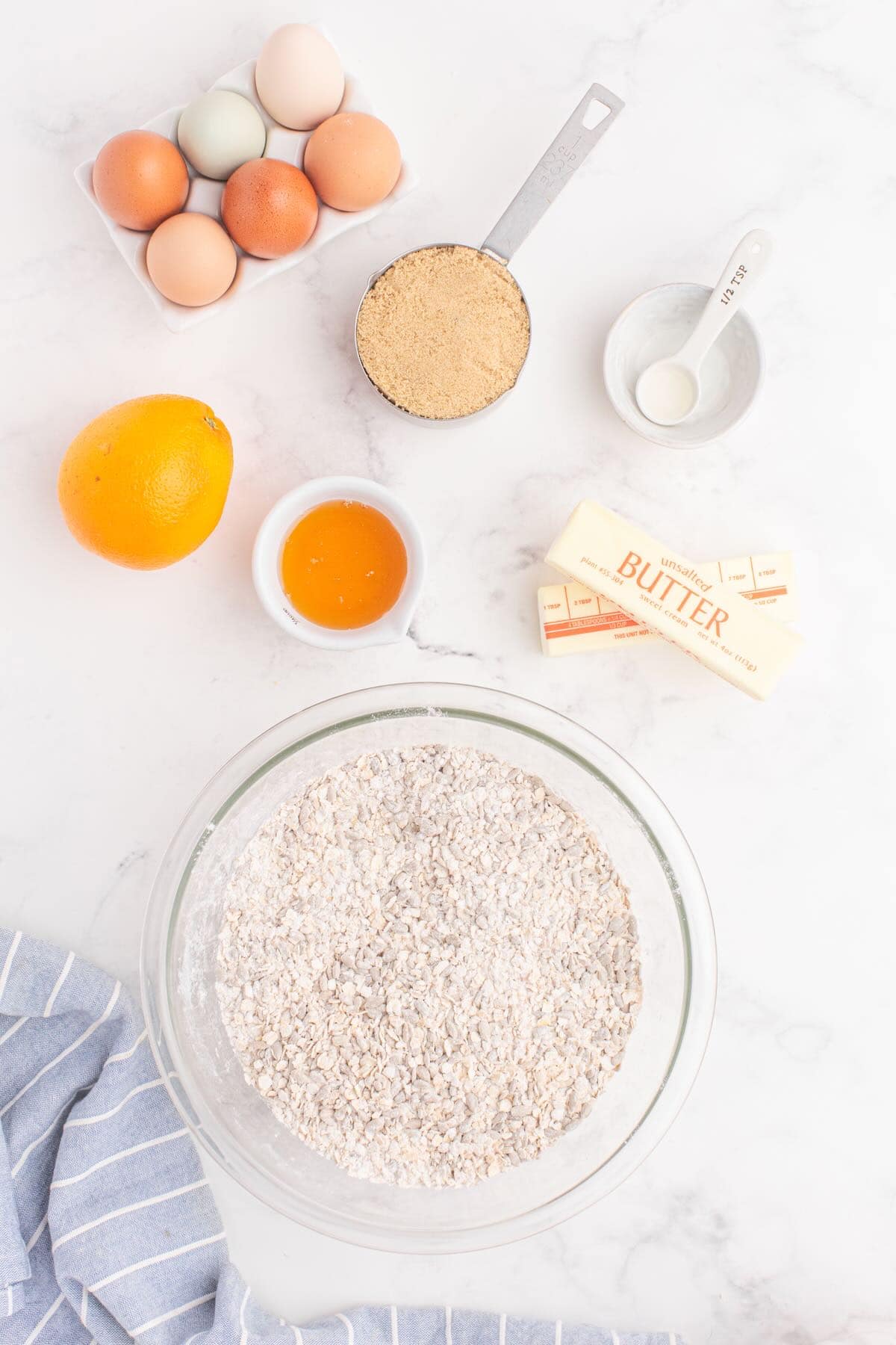 A bowl full of flour, sunflower seeds, and oatmeal. 