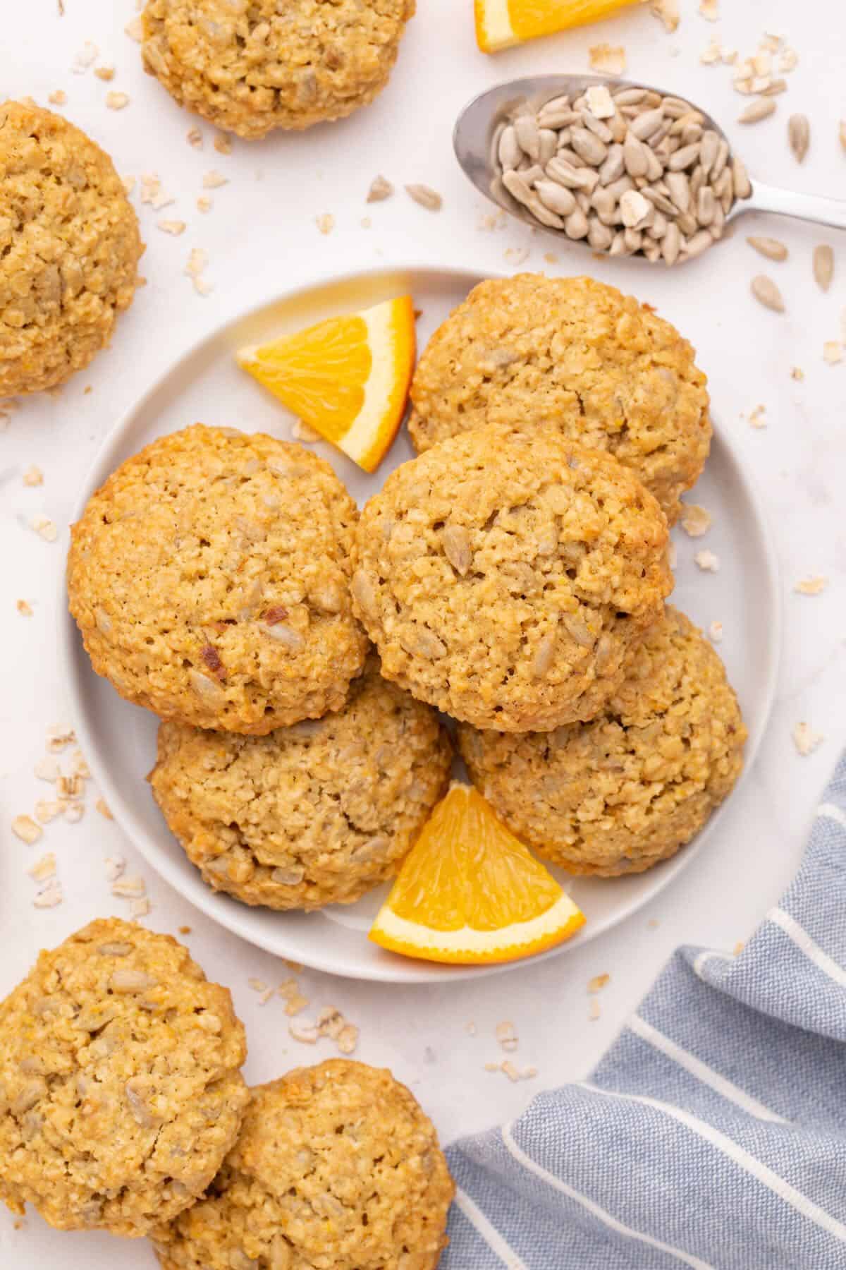 A plate full of cookies and fresh orange wedges. 