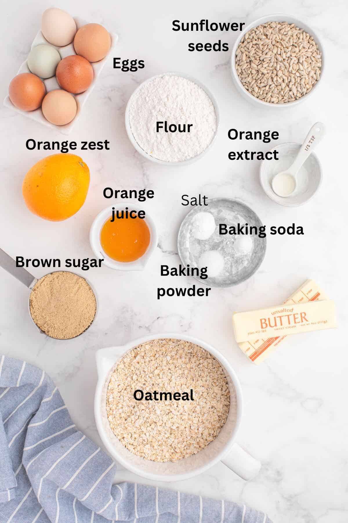 Cookie ingredients on a counter including flour, oatmeal, and sunflower seeds. 