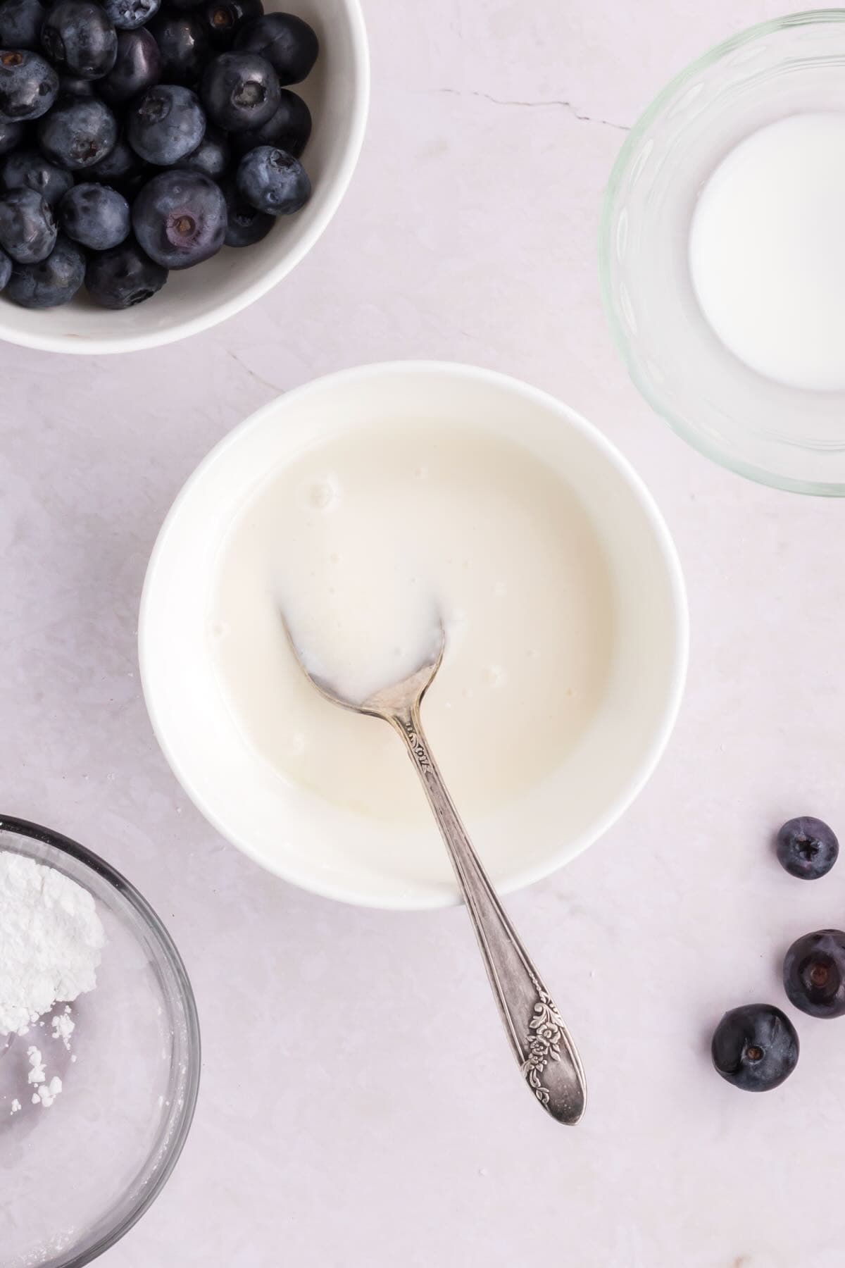 Powdered sugar and milk combined in a bowl to make a glaze.