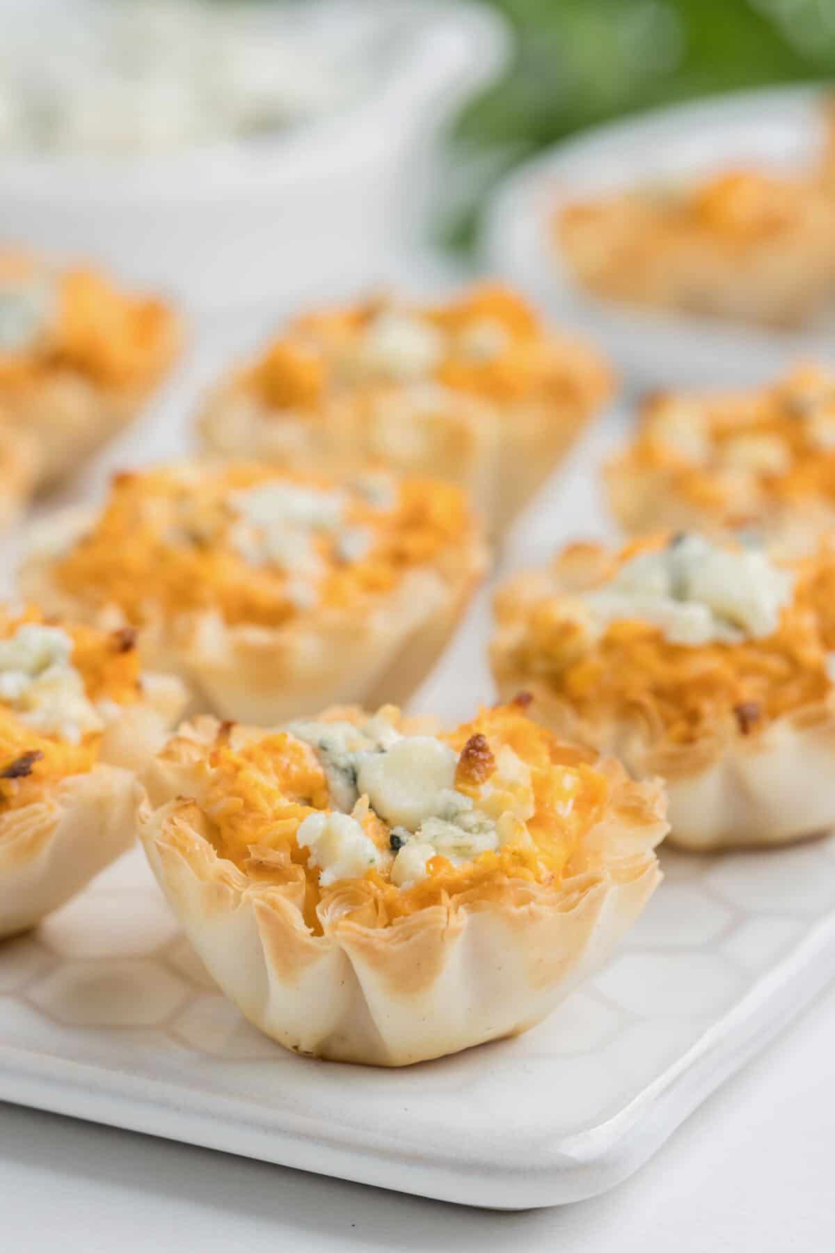 Baked buffalo chicken appetizers on a cutting board.