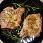 Two baked pork chops in a cast iron skillet with sprigs of rosemary.