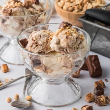 A glass dish full of scoops of Snickers Ice Cream.