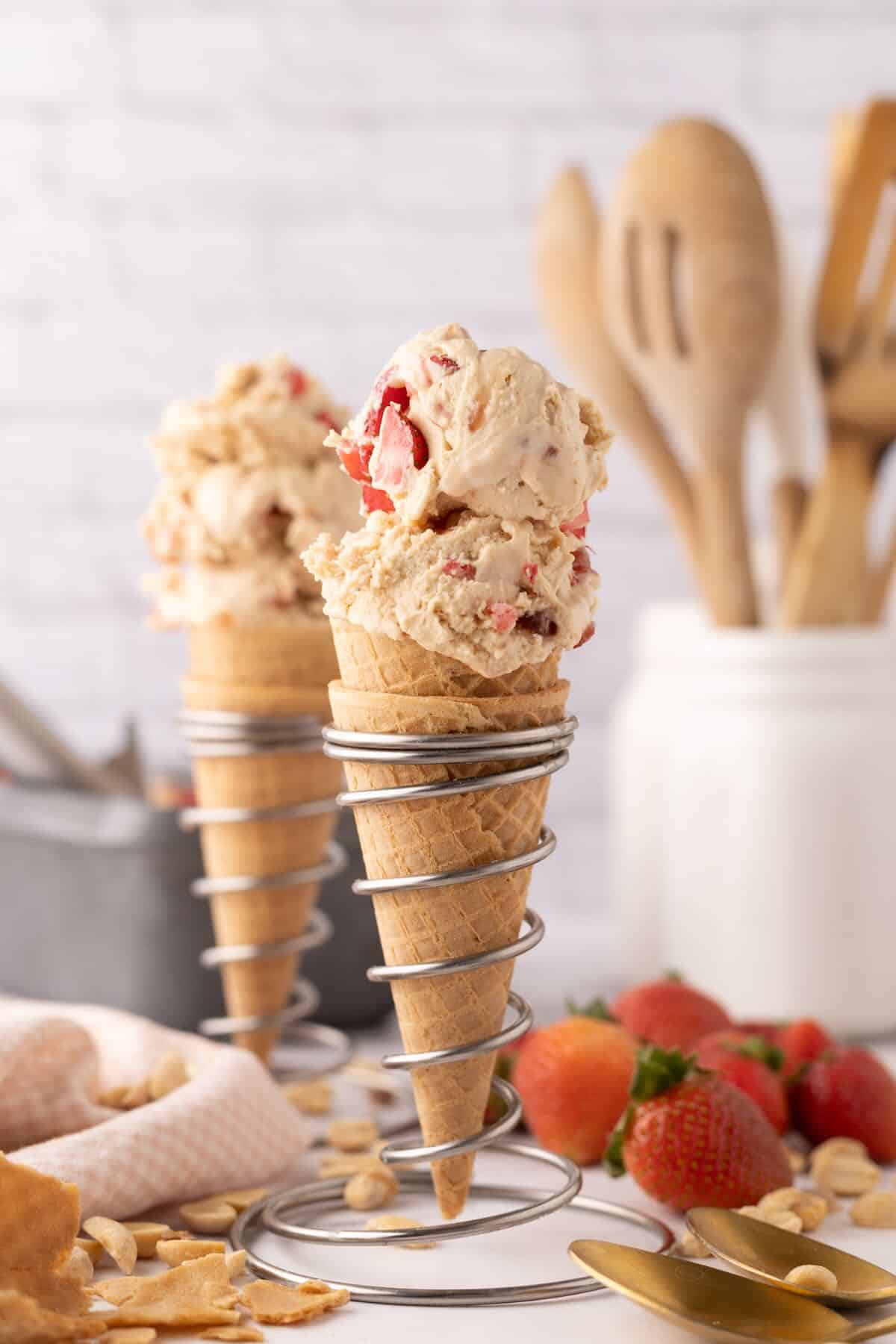 Two sugar cones full of peanut butter and jelly ice cream. 