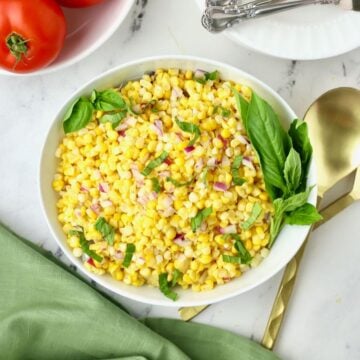 Southern Corn Salad in a white bowl garnished with strips of basil.