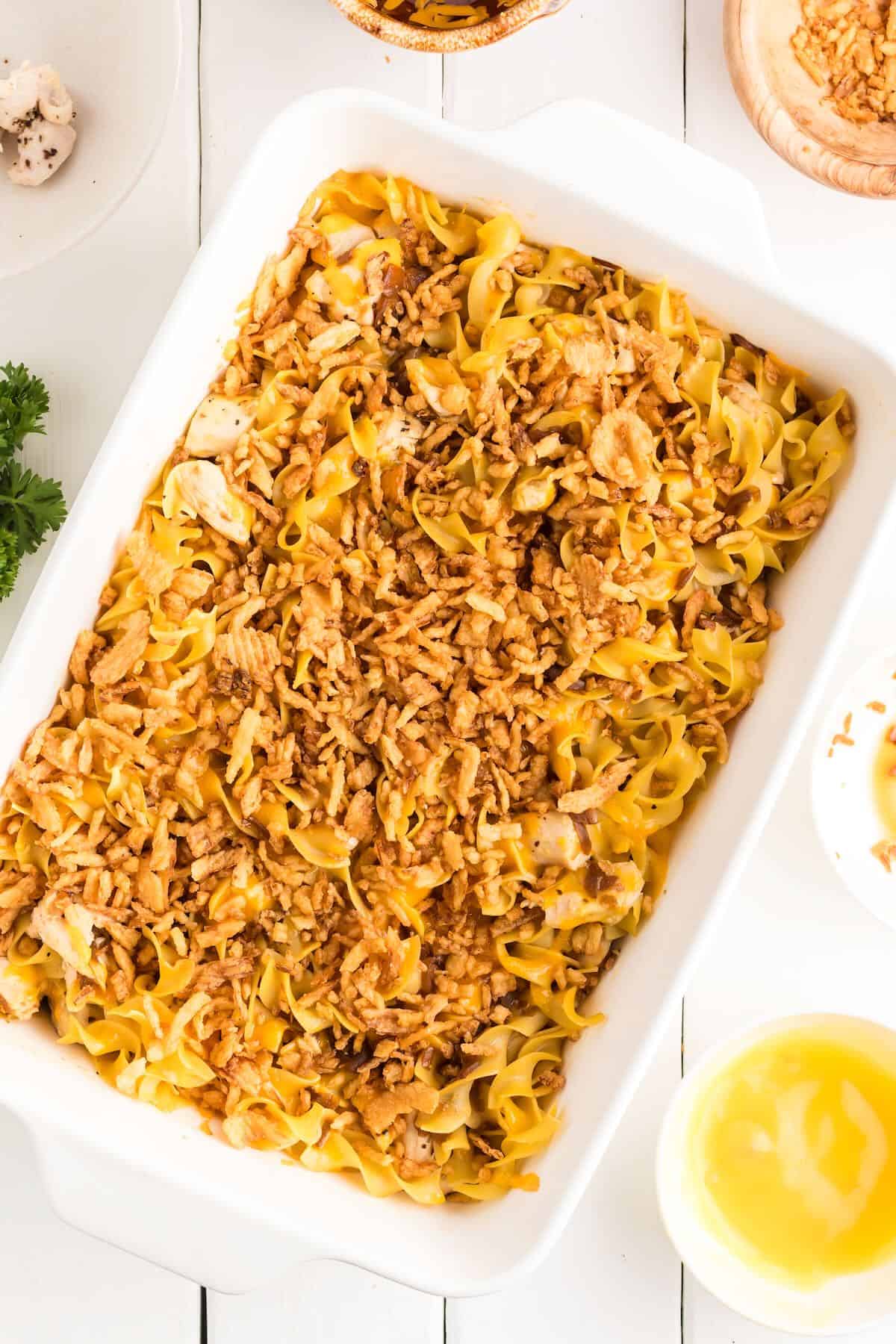 A chicken casserole with noodles topped with French fried onions.