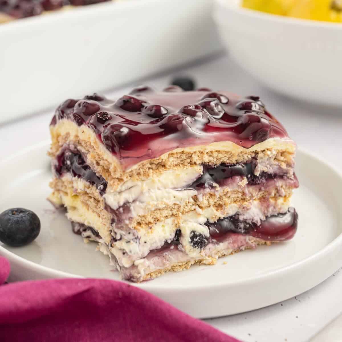 A square of a lemon blueberry icebox cake on a white plate.
