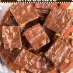 A wooden plate full of peanut butter and chocolate rice krispie treats.