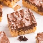 Peanut Butter and Chocolate Rice Krispie Bars cut on a counter with several chocolate chips scattered around.