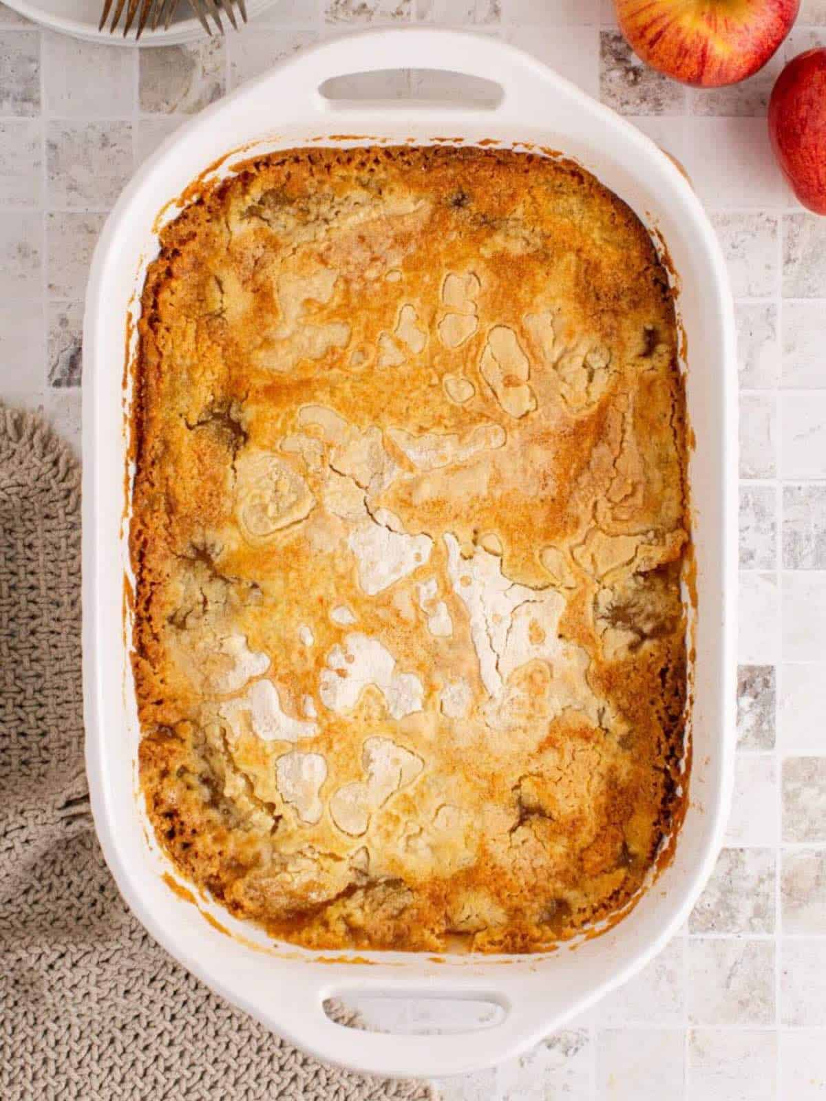 Baked apple cobbler in a white baking dish.