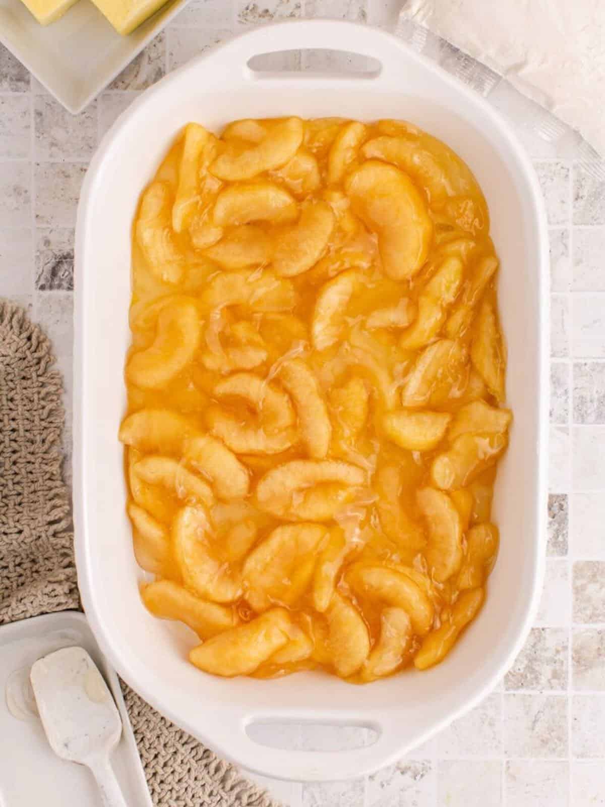 Apple pie filling in a white baking dish. 