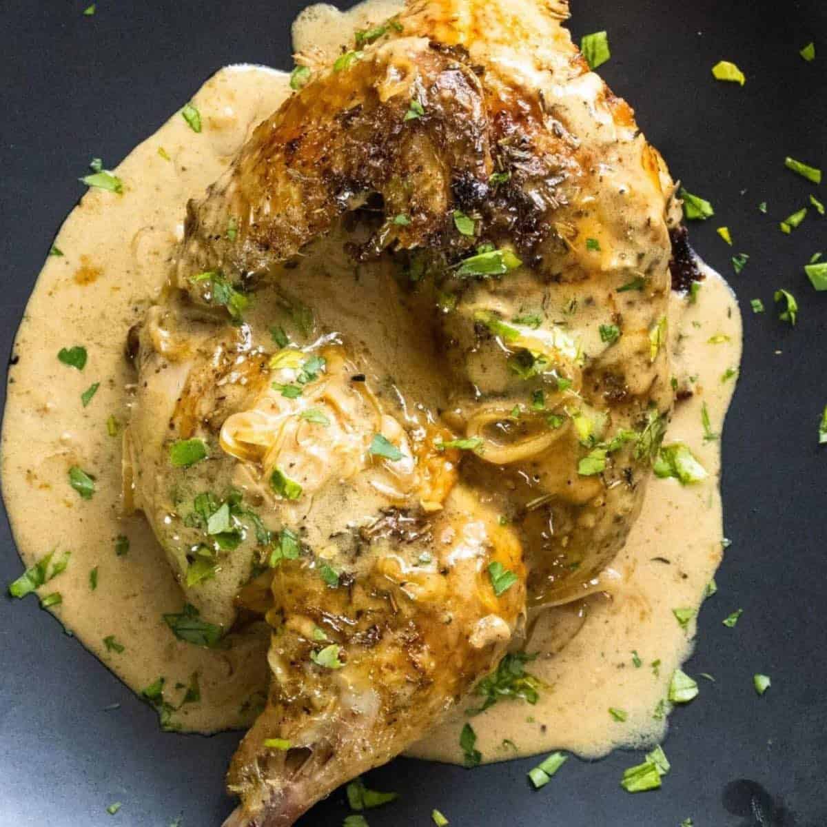 Half of a oven roasted cornish game hen covered in a creamy whiskey sauce. 