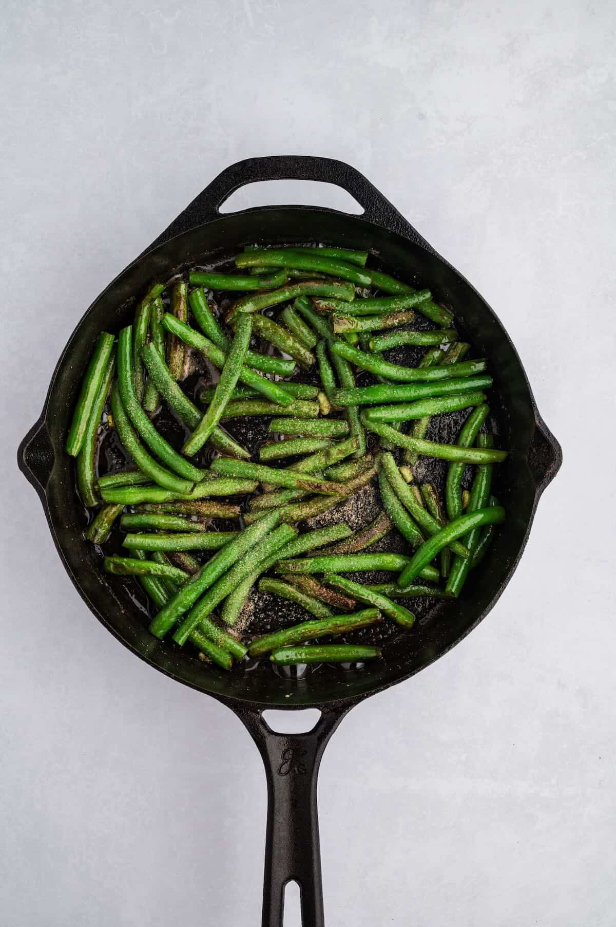 Blistered green beans that were sauteed in a cast iron skillet. 