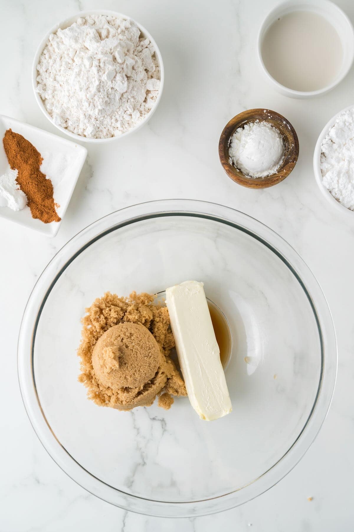 Brown sugar and a stick of butter in a clear glass bowl. 