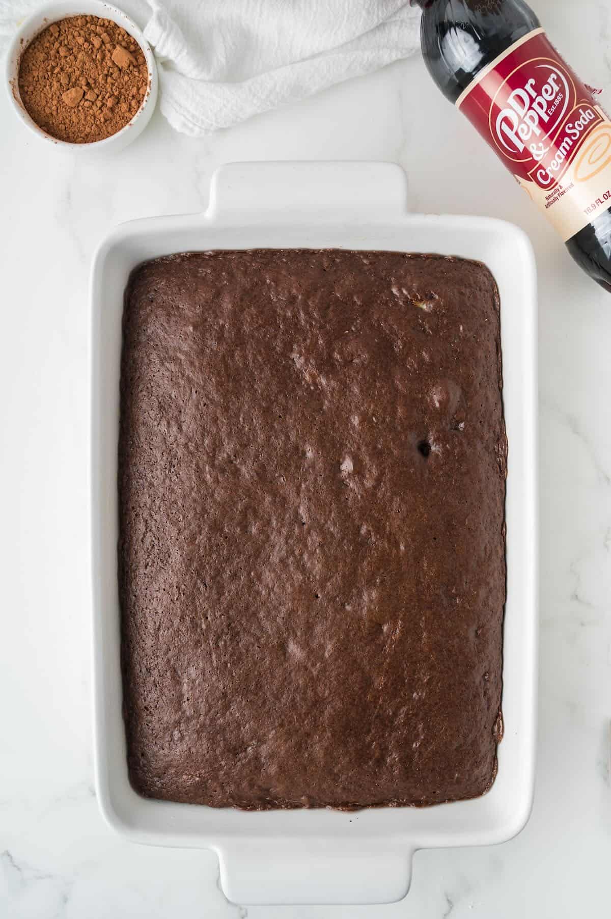 A baked chocolate sheet cake in a white baking dish. 