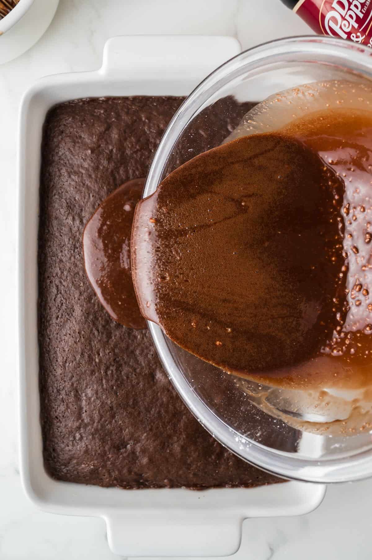 Pouring warm chocolate icing over a chocolate sheet cake. 
