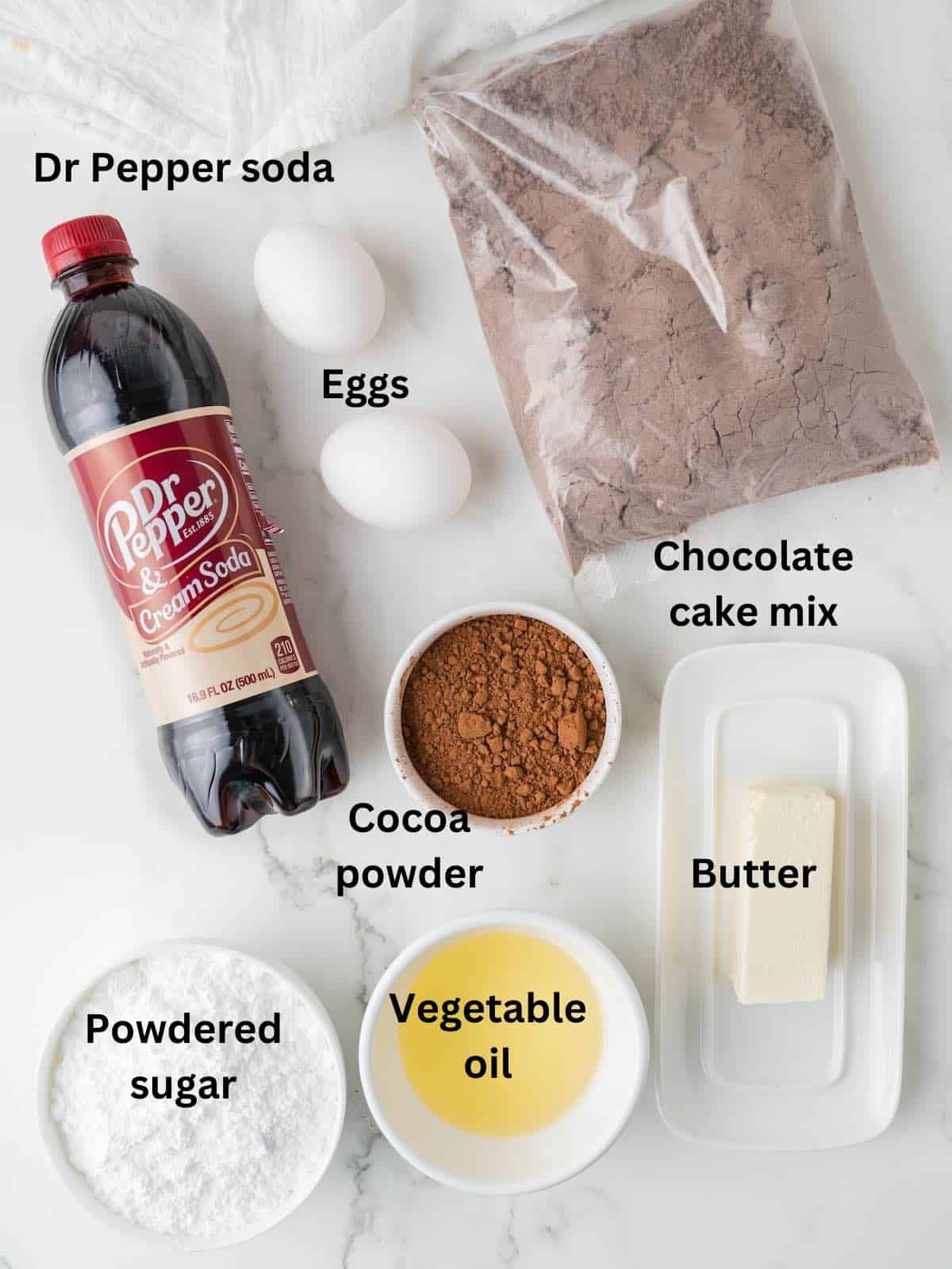 A bag of chocolate cake mix, a Dr pepper soda, vegetable oil, cocoa powder, and powdered sugar. 