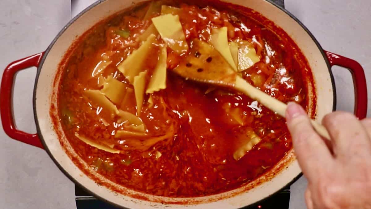 Lasagna soup cooking in a large Dutch oven with lasagna noodles.