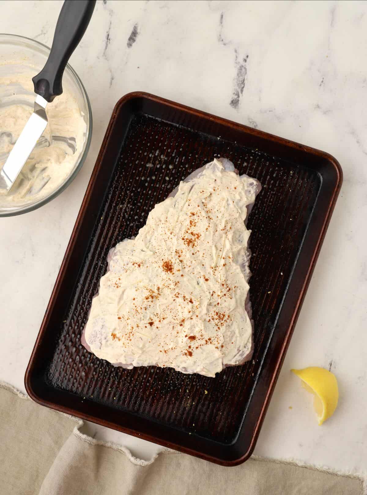 A grouper fillet coated in sour cream and topped with paprika.